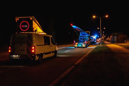 Nächtlicher Schwertransport von Rotorblättern mit Begleitfahrzeug
