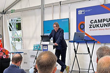 Mann steht an Rednerpult